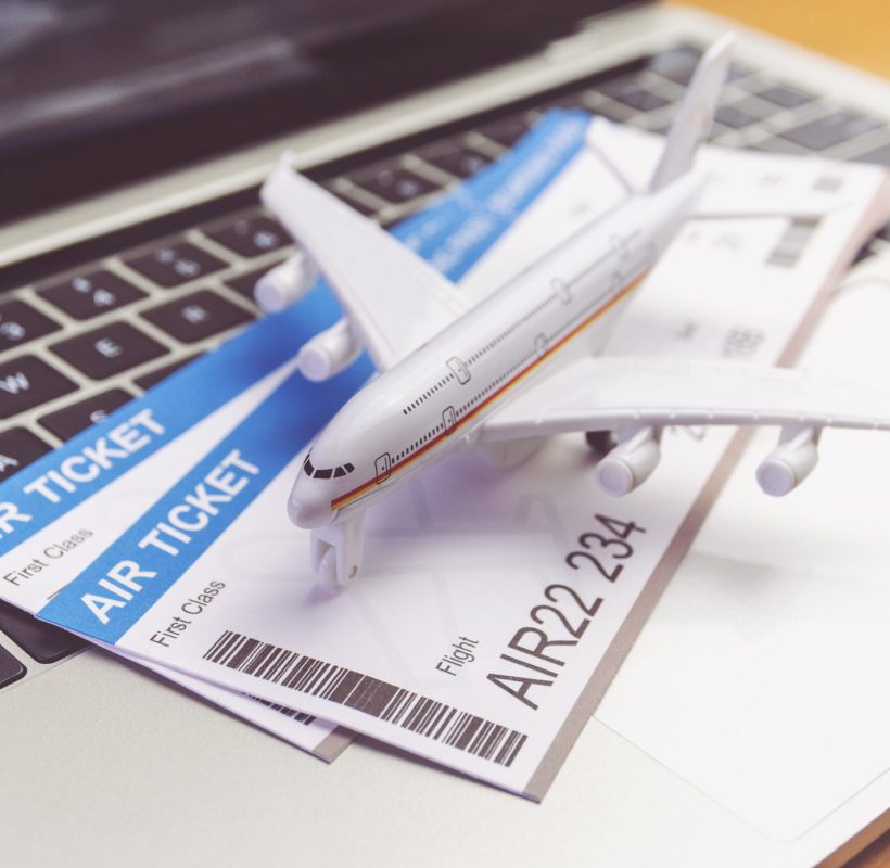 laptop computer and airplane and ticket on table. Online ticket booking concept